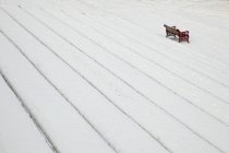 Passi coperti di neve e una panchina del parco in inverno — Foto stock