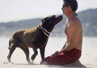 Сидячий чоловік і собака — стокове фото