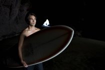 Surfista dentro una grotta a Muriwai Nuova Zelanda — Foto stock
