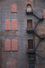 A Fire Escape Going Up The Side Of A Brick Building — Stock Photo