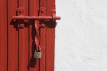 Portão trancado sobre a porta vermelha — Fotografia de Stock