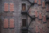 A Fire Escape Going Up The Side of a Brick Building — стоковое фото