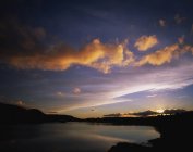 Puesta de sol sobre el agua del lago - foto de stock