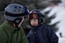 Pai e filho usando capacetes e máscaras de esqui — Fotografia de Stock