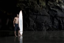 Surfista dentro una grotta a Muriwai Nuova Zelanda — Foto stock