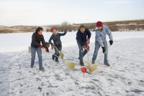 Щаслива кавказька сім'я на зимових вихідних грає в м'яч з віниками — стокове фото