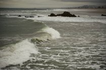 Wellen brechen zusammen, als sie auf das Ufer treffen — Stockfoto