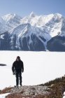 Напрямку Kananaskis країни, Альберта, Канада; Чоловічий мандрівного взимку з вкриті снігом гори і верхню напрямку Kananaskis озеро — стокове фото