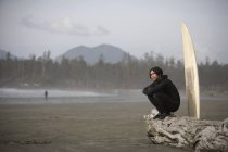 Surfeur assis sur la plage — Photo de stock