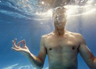 Человек, занимающийся медиацией, позирует под водой — стоковое фото