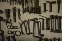 Alte Werkzeuge hängen an der grauen Wand — Stockfoto