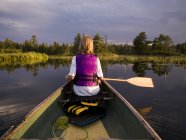 Vue arrière du canoë-kayak féminin dans le lac — Photo de stock