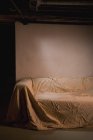 Canapé abandonné recouvert de drap de lit, espace de copie — Photo de stock