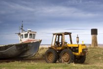 Tractor tirando lejos viejo barco de pesca - foto de stock