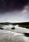 Conducción de coches por Flooded Road, Yorkshire, Inglaterra - foto de stock