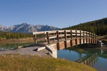 Footbridge At Ponds with mountains — Stock Photo