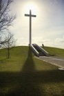 Kreuz gegen Sonne auf Hügel — Stockfoto