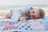Petit garçon étendu sur une couverture sur la plage, Malaga, Andalousie, Espagne — Photo de stock