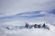 Picos de montaña sobre nubes - foto de stock