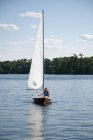Giovane donna che nuota in barca a vela, Lago dei boschi, Ontario, Canada — Foto stock