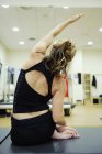 Visão traseira da mulher se exercitando no ginásio — Fotografia de Stock