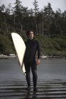Surfer in piedi sulla spiaggia, Cox Bay vicino a Tofino, Columbia Britannica, Canada — Foto stock