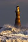 Wellen krachen gegen einen Leuchtturm — Stockfoto