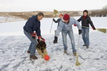 Família caucasiana feliz no fim de semana de inverno passar tempo juntos e brincando com o cão — Fotografia de Stock