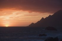 Coucher de soleil sur la côte rocheuse — Photo de stock