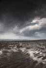 Сохнувший песок под тёмными облаками — стоковое фото