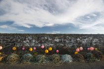 Colorful buoys and ropes hanging along stone wall. dumfries and galloway, scotland — Stock Photo