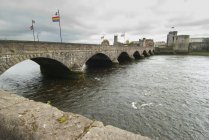 Прапори над річкою з замком — стокове фото