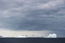Icebergs bajo el cielo nublado - foto de stock
