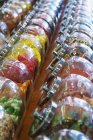 Frascos de varios dulces en filas con fondo borroso - foto de stock