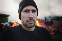 Un hombre de pie con un fuego ardiendo detrás de él; Dunsborough West australia australia - foto de stock
