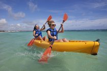 Due donne in giubbotti di salvataggio remare in una barca gialla; Punta Cana, La Altagracia, Repubblica Dominicana — Foto stock
