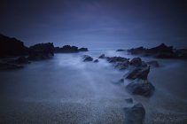 Lunga esposizione di rocce sulla spiaggia — Foto stock