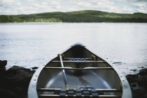 Fiberglass canoe at lakeside with mountain — Stock Photo