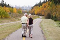 Mature married couple walking together in park during fall season;Edmonton alberta canada — Stock Photo