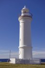 Белый маяк против голубого неба — стоковое фото