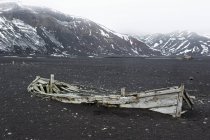 Broken abandoned wooden boat on shore — Stock Photo