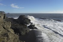 Água ondulada contra a costa — Fotografia de Stock