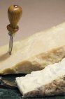Bloc de fromage parmesan et gorgonzola sur plaque ronde en marbre avec couteau — Photo de stock
