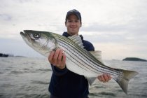 Man holding fresh caught striped bass. boston, massachusetts, united states of america — Stock Photo