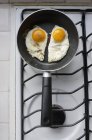 Due uova fritte di lato soleggiato in una pentola su un forno — Foto stock