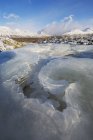 Hielo en el arroyo que conduce al valle cubierto de nieve - foto de stock
