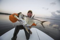 Un homme tient fièrement un gros poisson frais pêché à l'arrière d'un bateau ; Puerto rico — Photo de stock