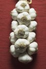 Fresh garlic heap hanging on rope — Stock Photo
