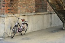 Bicycle parked beside wall — Stock Photo