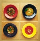 Quattro piatti di alimenti — Foto stock